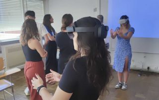 Grupo de pessoas em uma sala de aula, com um headset de realidade virtual