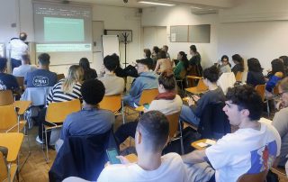 Grupo de pessoas sentadas em uma sala de aula