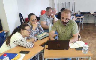 Grupo de pessoas participando numa reunião e computador