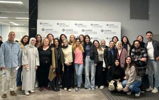 Grupo de pessoas posando e sorrindo para a fotografia.