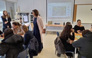 Estudantes e professores numa sala de aula com jogo de tabuleiro