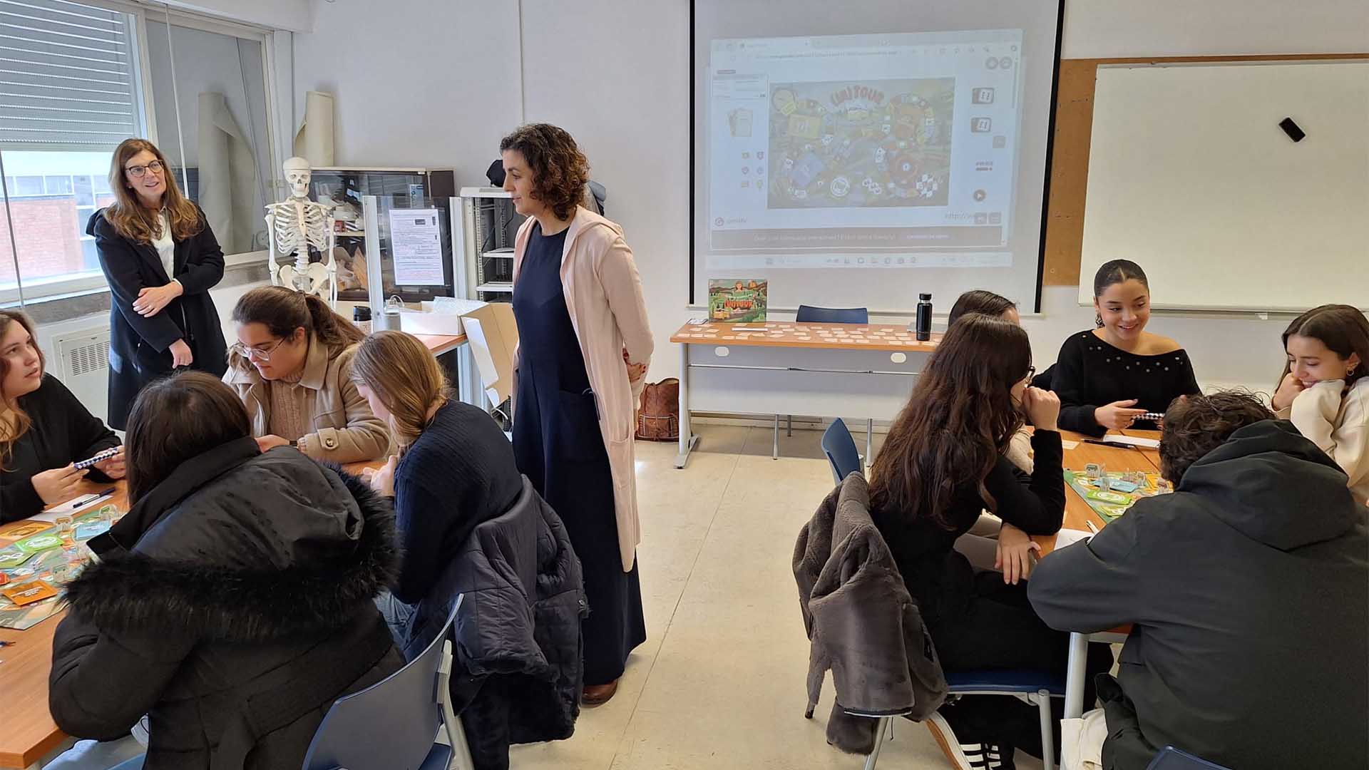 Estudantes e professores numa sala de aula com jogo de tabuleiro