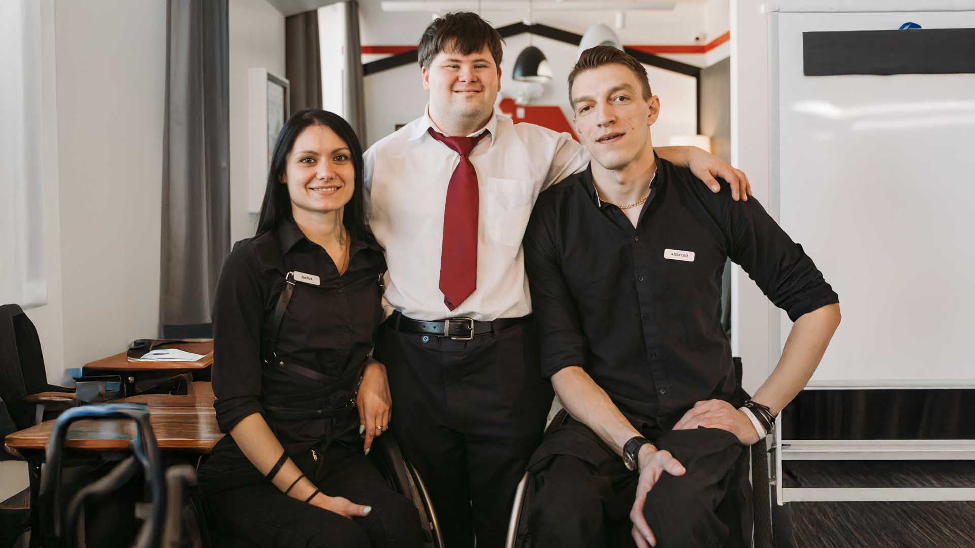 foto com pessoas inclusivas a darem um abraço no seu local de trabalho