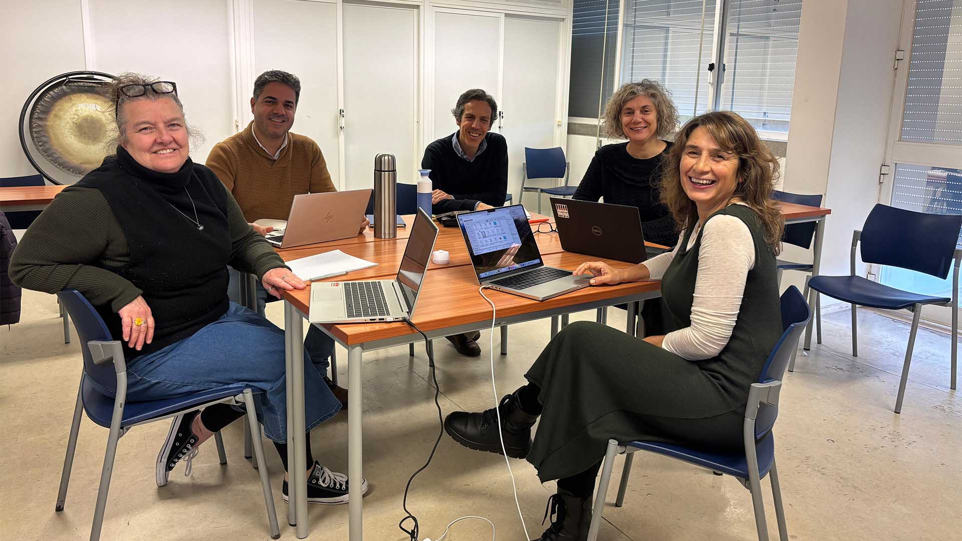 cinco professores reunidos em volta de uma mesa