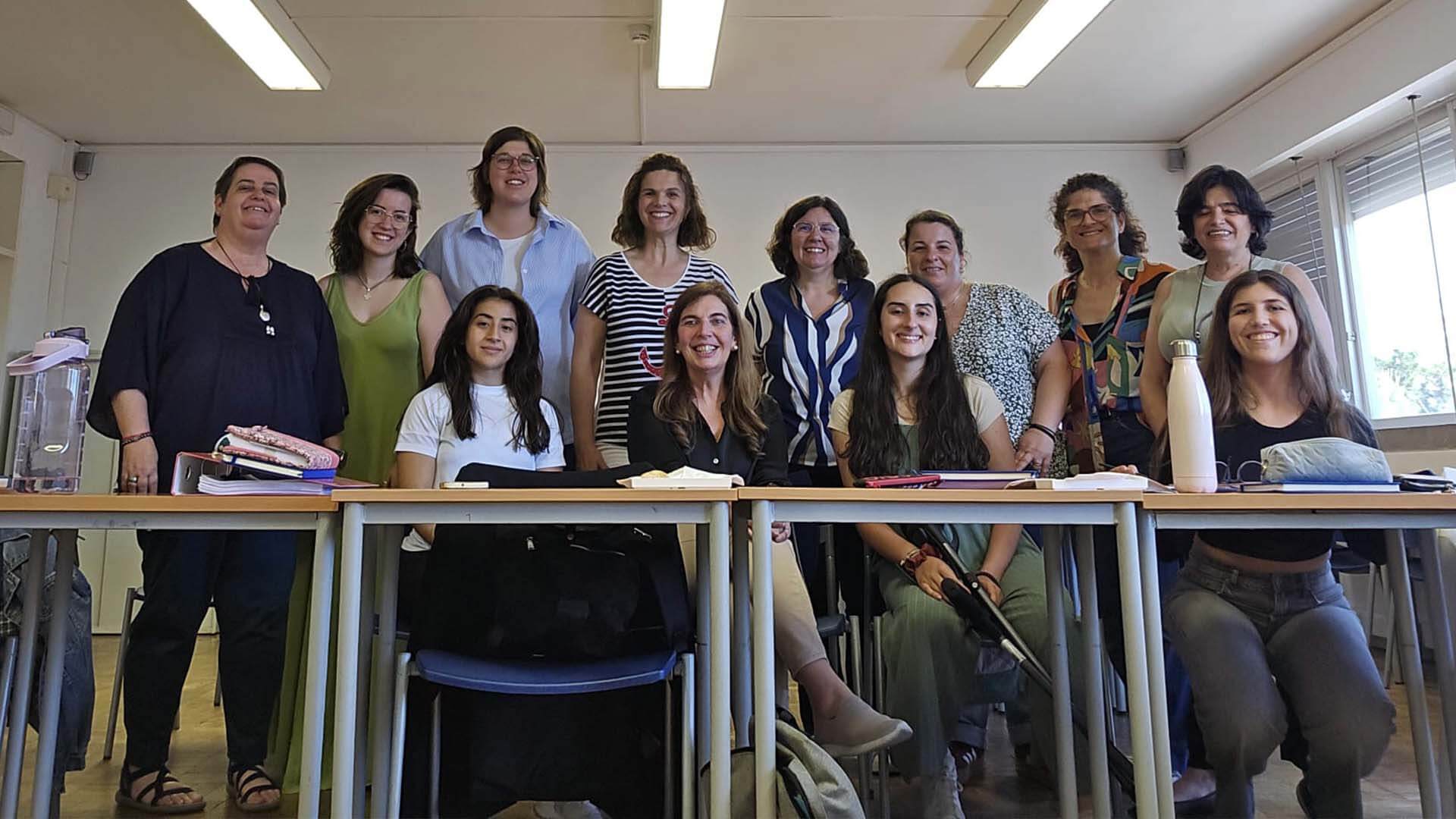 Grupo de estudantes e professora na sala de aula a pousar para a fotografia